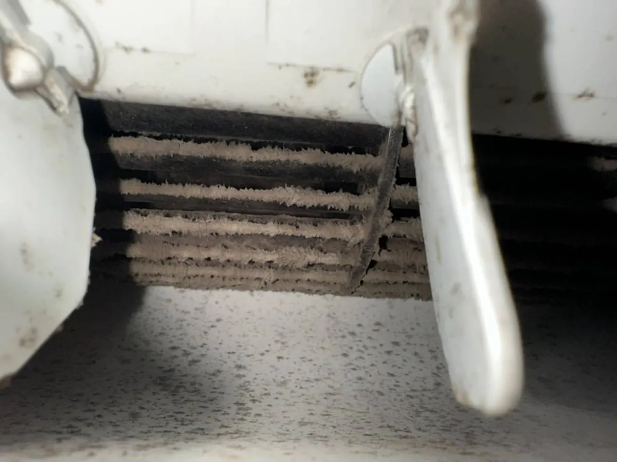 Aircon air outlet and blower packed with grey fluff