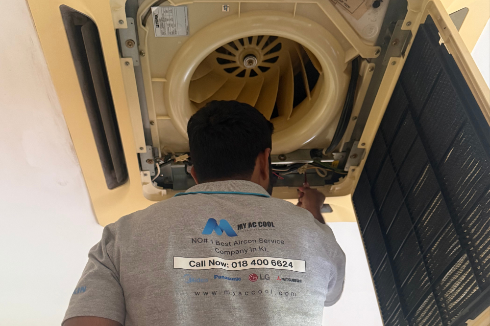 Technician cleaning a split‑type air‑conditioner in a KL office, My AC Cool maintenance service